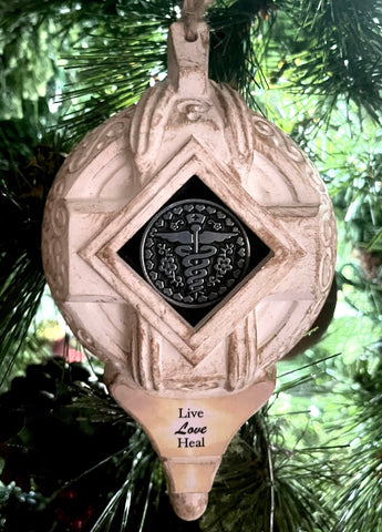 Decorative ornament with caudaceus symbol in center showcasing 'Live,Love,Heal"